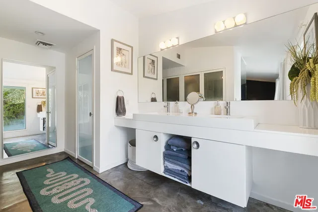 a bathroom with a double vanity sink mirror and bathtub