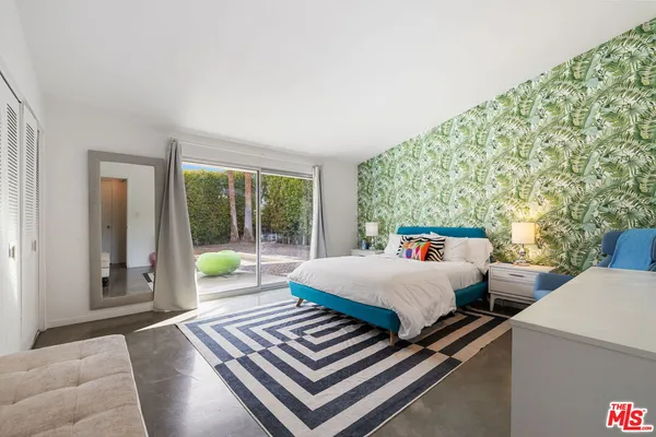 a bedroom with 2 bed and a large window