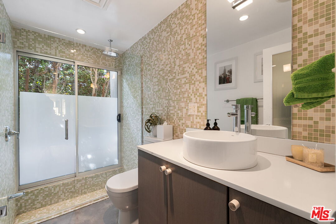 1155 East Mesquite Avenue Palm Springs, CA 92264 - Photo 22 of 32 a bathroom with a sink a toilet a mirror and shower