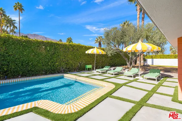 a view of a swimming pool with a patio and a yard