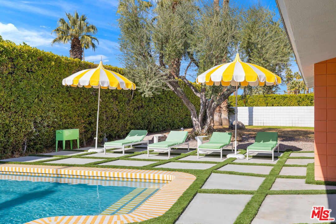 1155 East Mesquite Avenue Palm Springs, CA 92264 - Photo 28 of 32 a view of a swimming pool with a lounge chairs