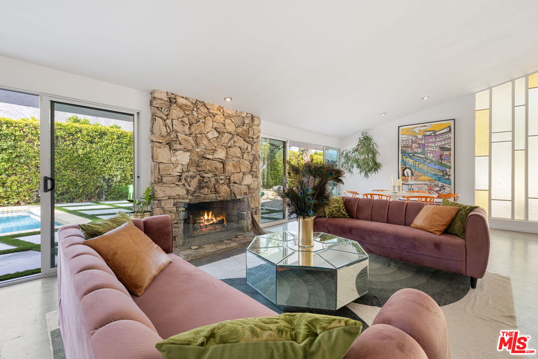 1155 East Mesquite Avenue Palm Springs, CA 92264 - Photo 5 of 32 a living room with furniture fireplace and a large window