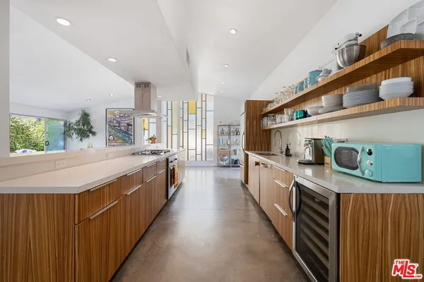 a kitchen with stainless steel appliances a sink and a wooden floor
