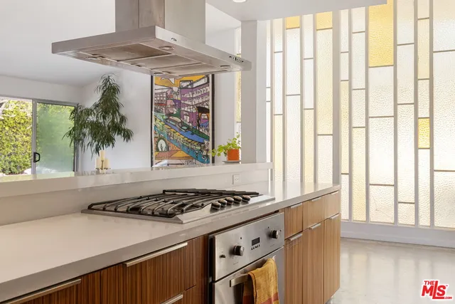 a kitchen with a stove a sink and a window