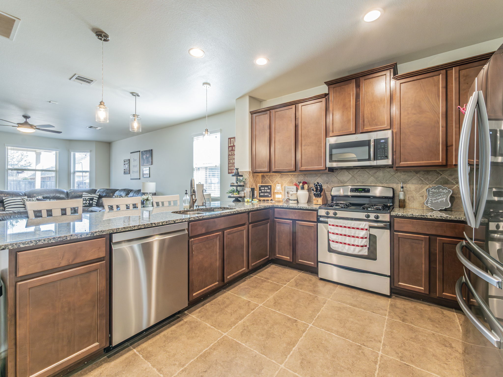 1366 Heep Run Buda, TX 78610 - Photo 34 of 37 Kitchen with stainless steel appliances, light stone countertops, hanging light fixtures, and open floor plan