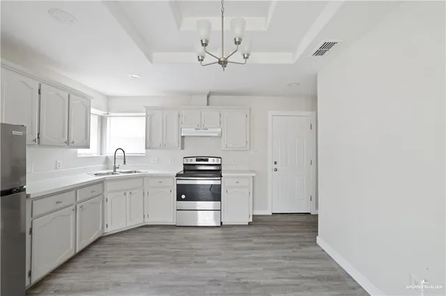 a kitchen with stainless steel appliances a white cabinet and a sink