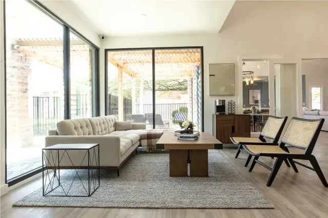 a living room with furniture a large window and a chandelier