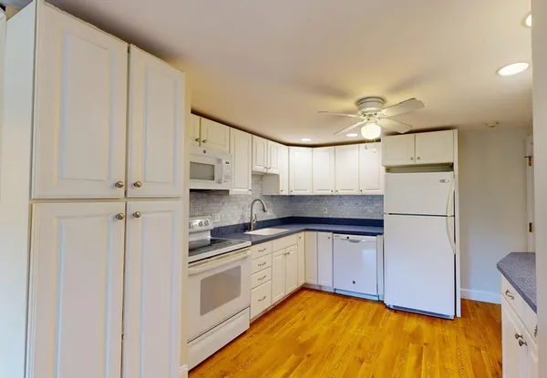 a kitchen with a sink a refrigerator and cabinets