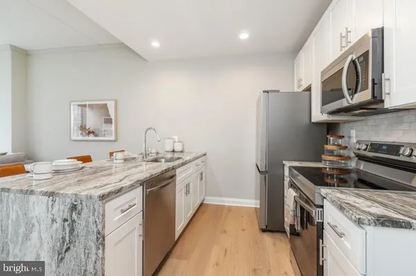 a kitchen with stainless steel appliances granite countertop a stove a sink dishwasher and a refrigerator