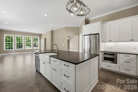 a kitchen with stainless steel appliances granite countertop a sink a stove and refrigerator