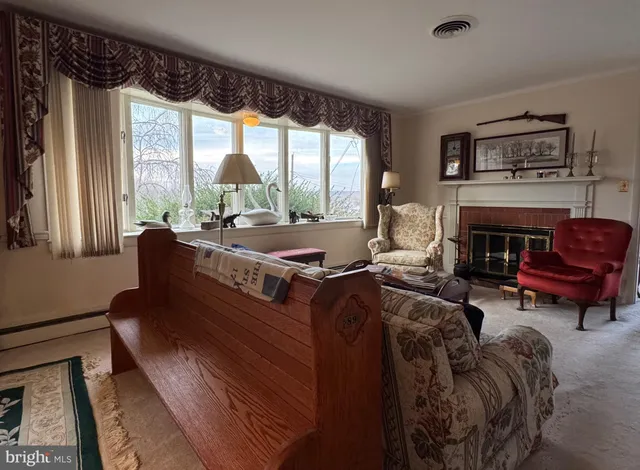 a living room with furniture fireplace and large windows