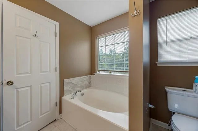 a white bath tub sitting next to a toilet