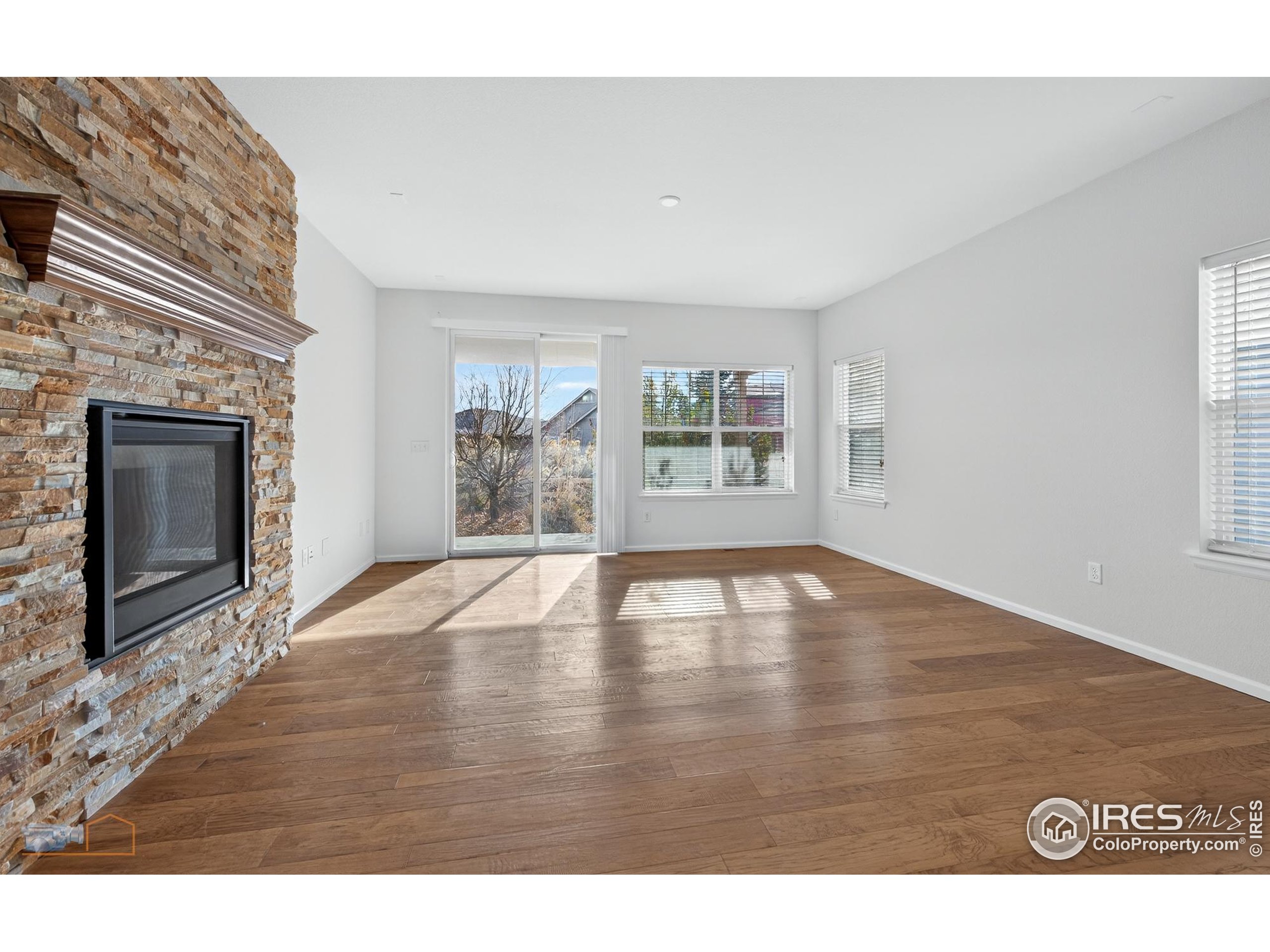 1435 Rustic Drive Longmont, CO 80504 - Photo 17 of 45 a view of empty room with wooden floor and fireplace