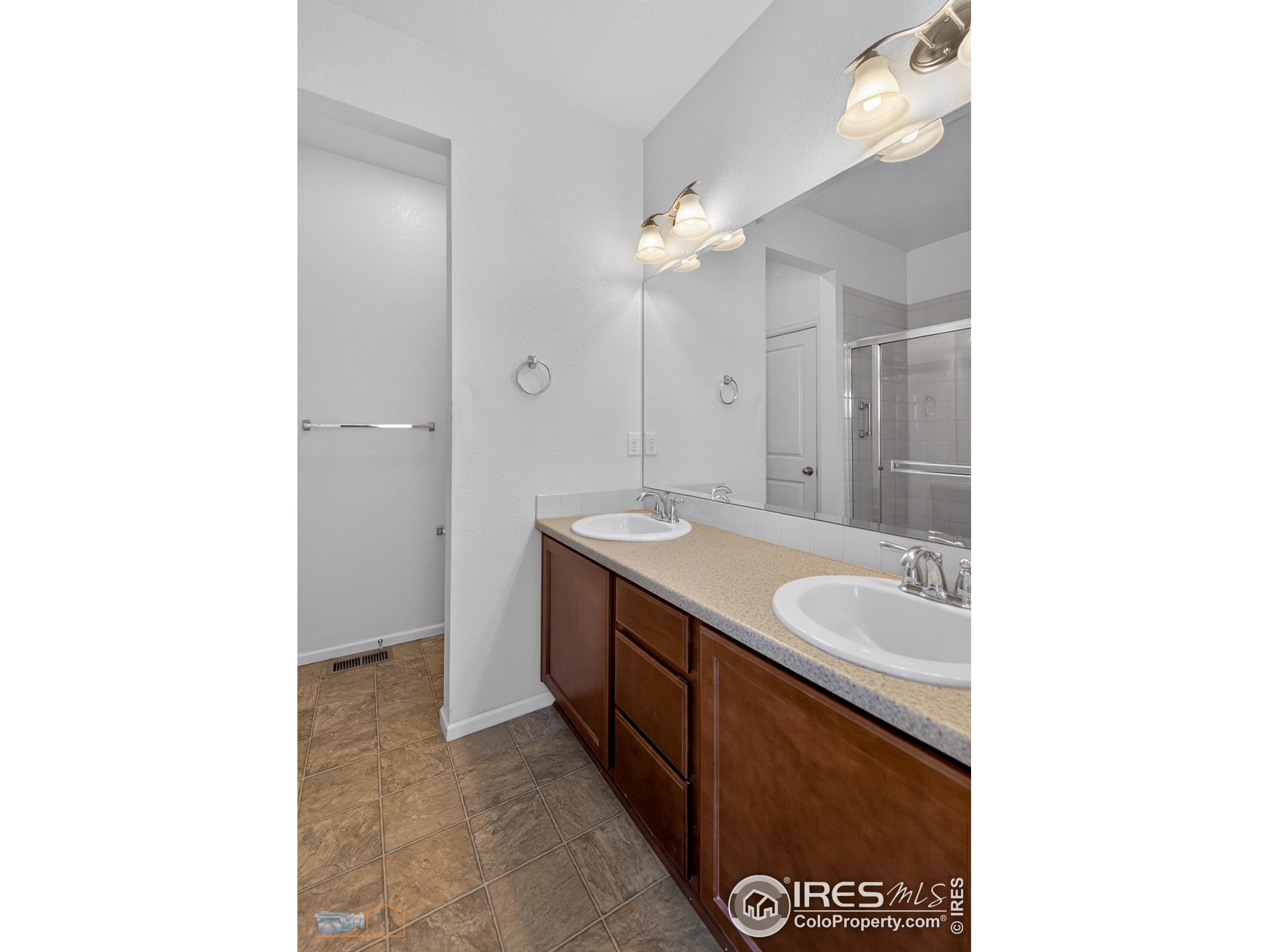 1435 Rustic Drive Longmont, CO 80504 - Photo 19 of 45 a spacious bathroom with a granite countertop sink and a mirror