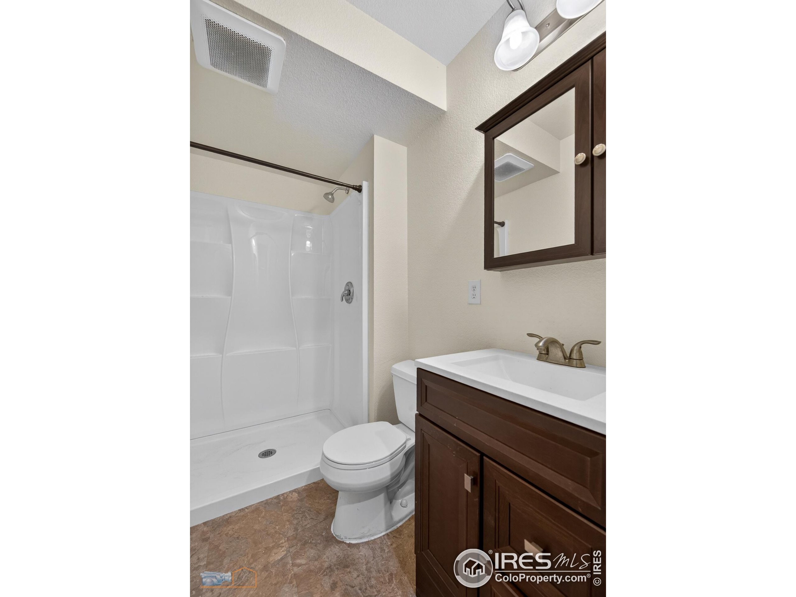 1435 Rustic Drive Longmont, CO 80504 - Photo 34 of 45 a bathroom with a granite countertop toilet sink and mirror