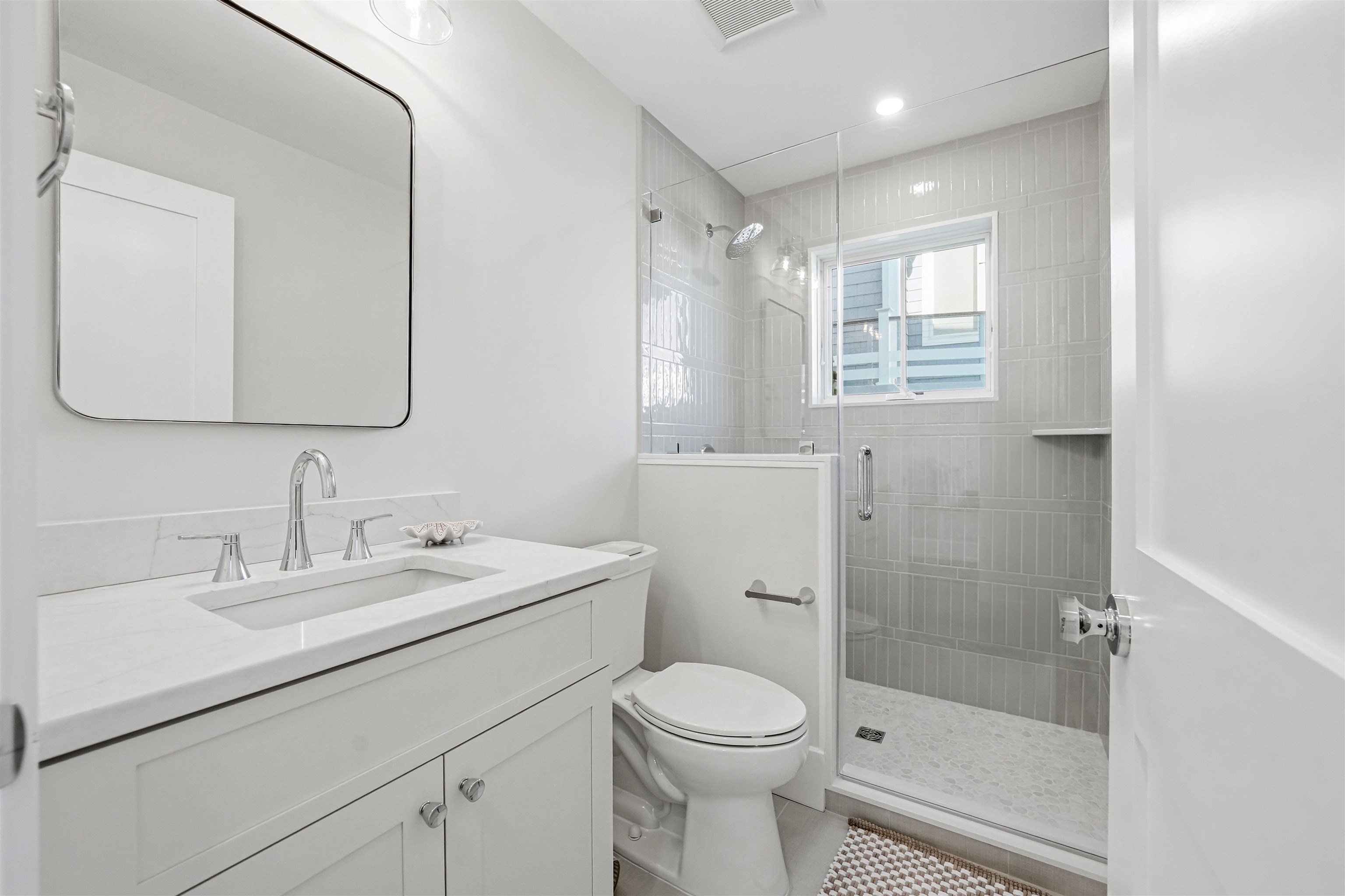46 West 31st Avalon, NJ 08202 - Photo 6 of 50 a bathroom with a toilet a sink a mirror a shower and vanity