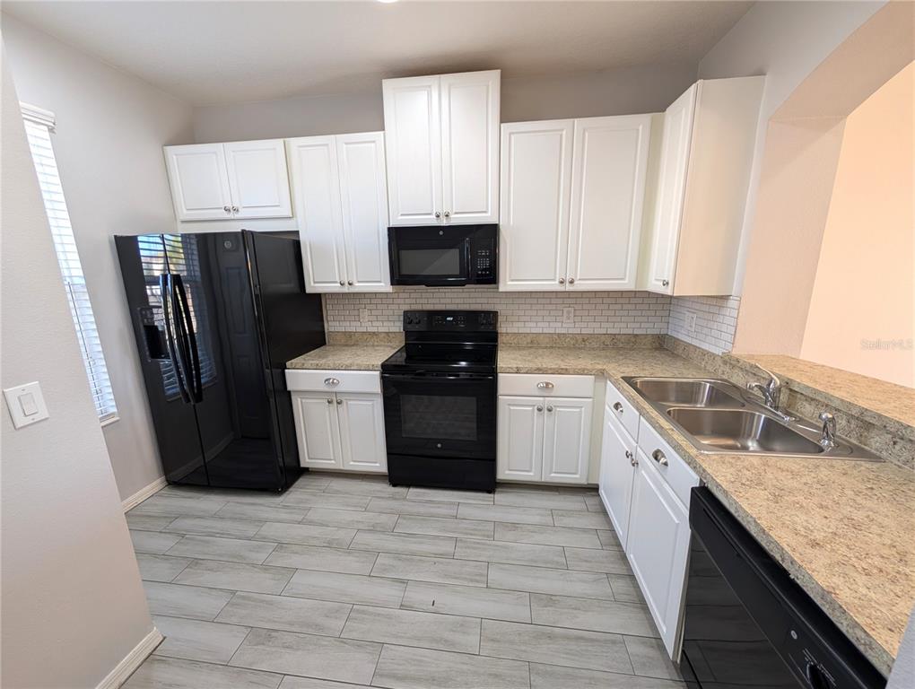 8955 Walnut Gable Court Riverview, FL 33578 - Photo 3 of 15 a kitchen with granite countertop a refrigerator stove and sink
