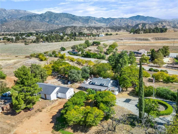 an aerial view of green landscape with trees houses and mountain view