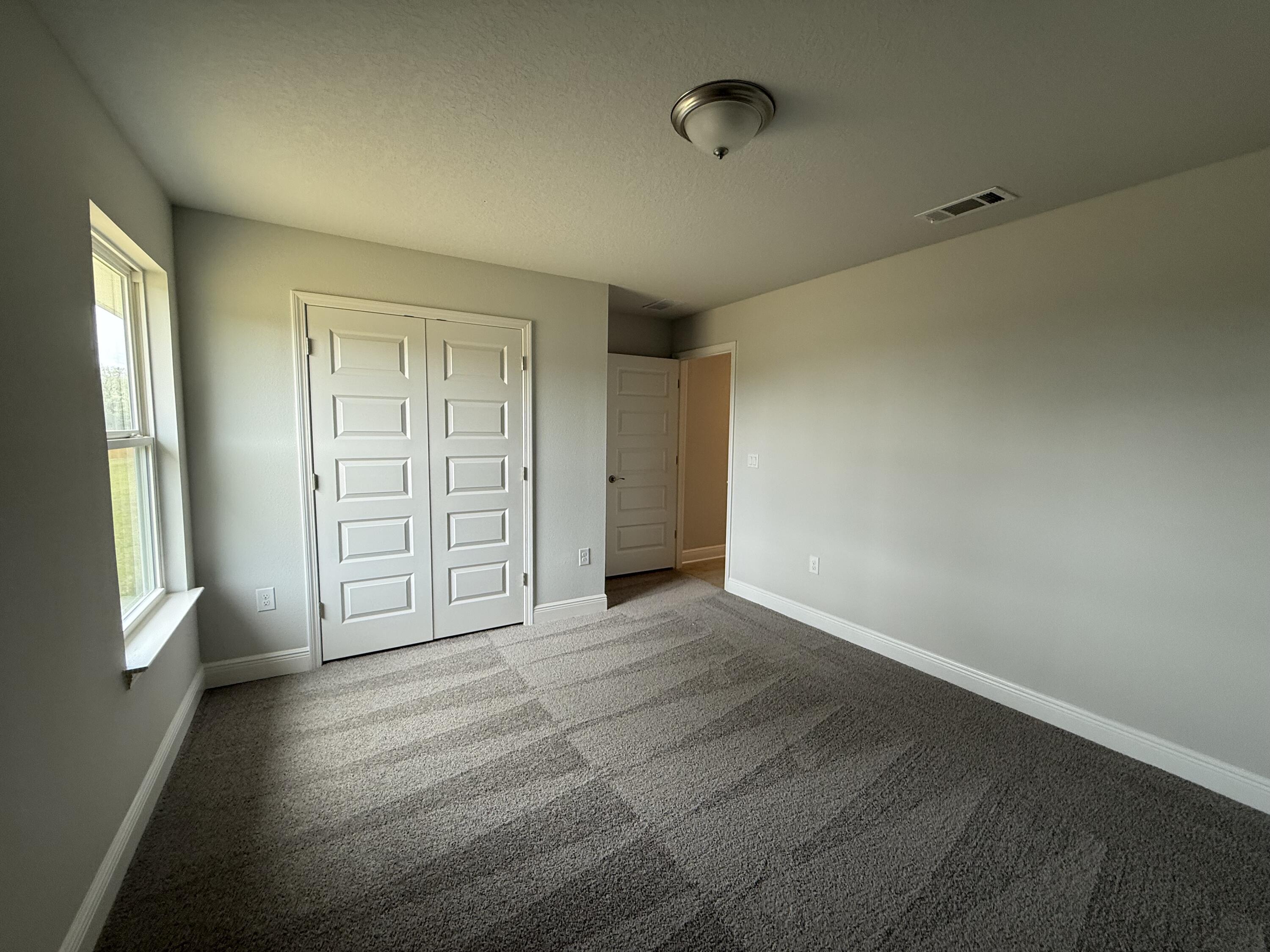 6002 Crocket Cove Crestview, FL 32539 - Photo 13 of 29 an empty room with windows and closet
