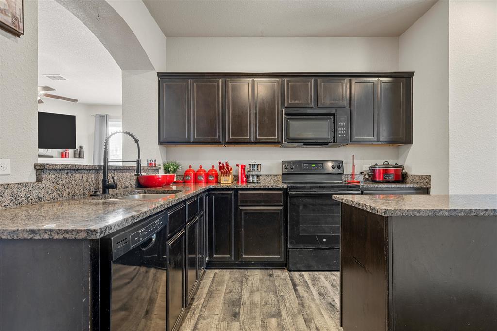 10620 Langham Drive Waco, TX 76708 - Photo 7 of 30 a kitchen with granite countertop a sink stainless steel appliances and cabinets