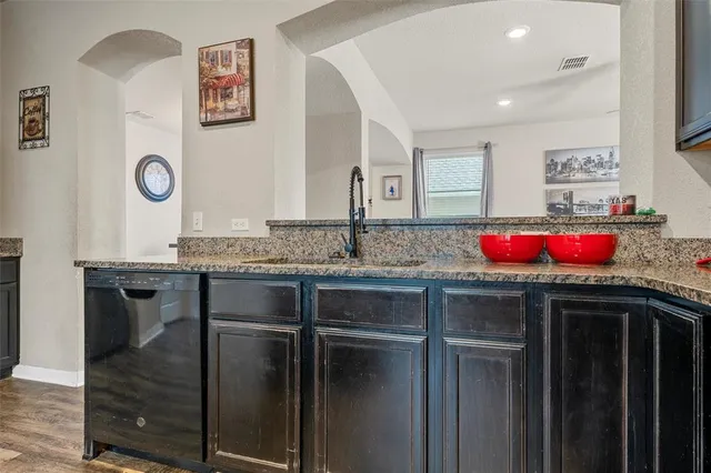 a kitchen with granite countertop cabinets a sink and appliances