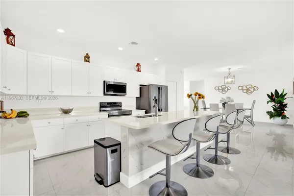 a kitchen with furniture a center island and stainless steel appliances