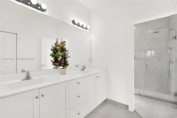 a bathroom with a double vanity sink mirror and shower