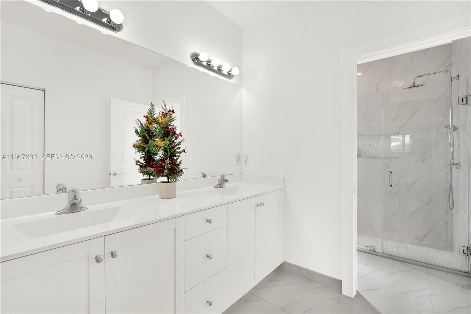 19059 Southwest 134th Court Miami, FL 33177 - Photo 26 of 52 a bathroom with a double vanity sink mirror and shower