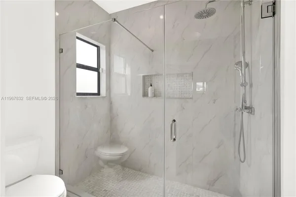 a bathroom with a toilet and a shower