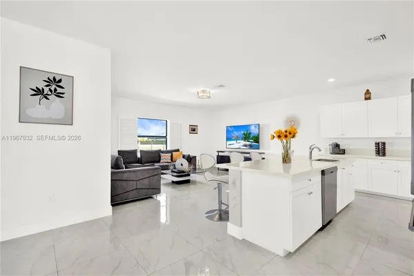a living room with furniture and white appliances