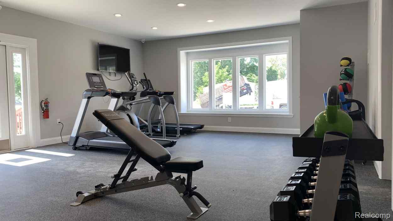 92 Normandy Drive Howell, MI 48843 - Photo 21 of 24 Dedicated fitness space featuring a rubber flooring system, recessed lighting, and a multi-pane bay window