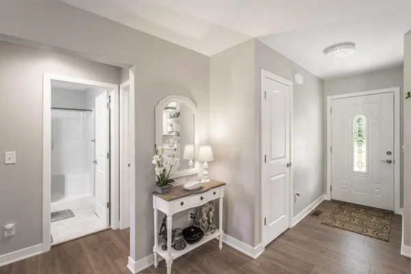 a view of a livingroom with kitchen and front door