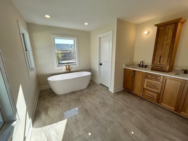 a spacious bathroom with a bathtub sink and mirror