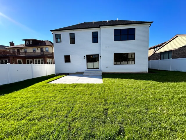a view of a house with backyard and sitting area