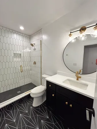a bathroom with a double vanity sink toilet mirror and shower