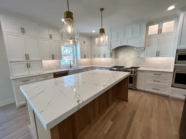 a kitchen with stainless steel appliances granite countertop a sink a stove and a wooden floors