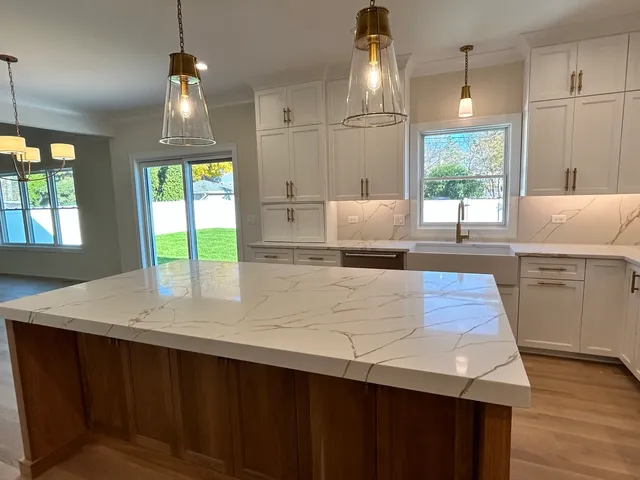 a kitchen with kitchen island a stove a counter top space and a window