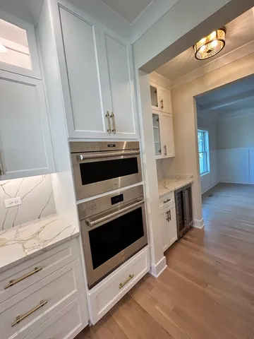 a kitchen with granite countertop white cabinets and white appliances