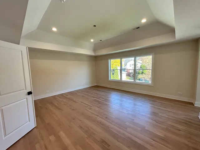 an empty room with wooden floor and window