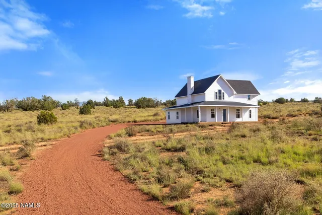 a view of a brick house next to a yard with trees