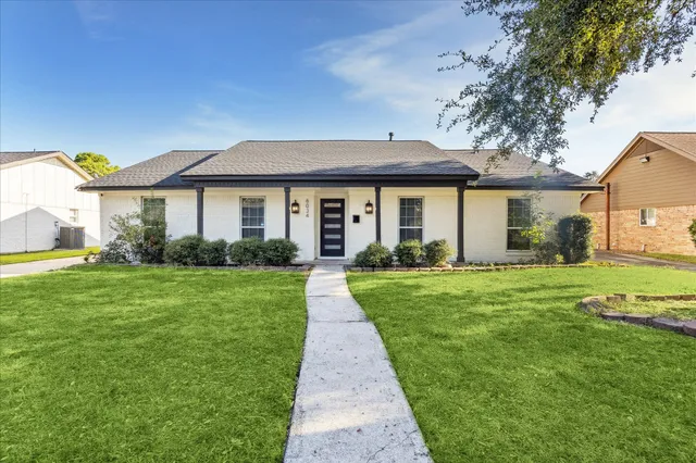 a front view of a house with a yard and garden