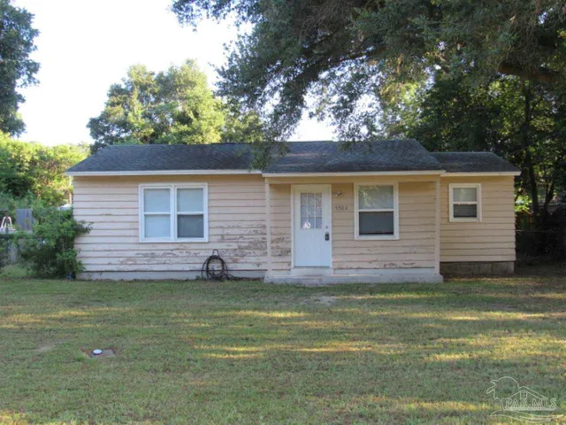 a view of a yard with a house and a large tree