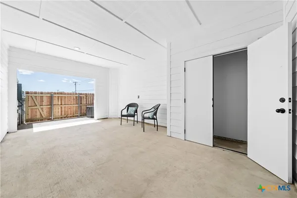 an empty room with a fireplace and windows