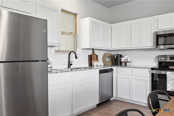 a kitchen with a sink appliances and cabinets
