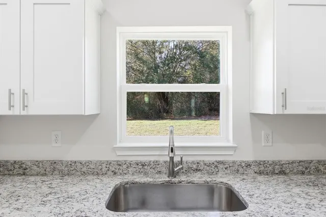 a kitchen with granite countertop a sink and a window