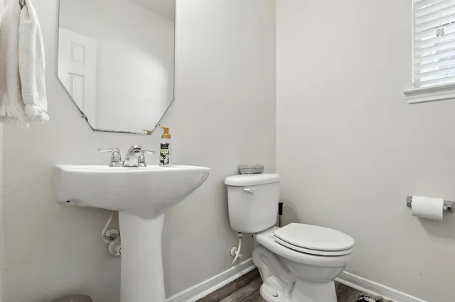 a bathroom with a sink toilet and a mirror