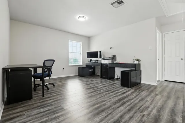 a view of a workspace with furniture and wooden floor