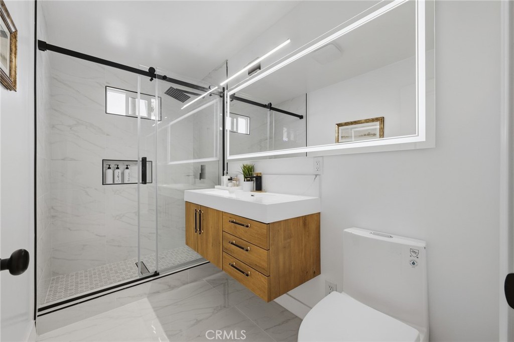 1280 East Woodbury Road Pasadena, CA 91104 - Photo 30 of 40 a bathroom with a sink a mirror and a toilet