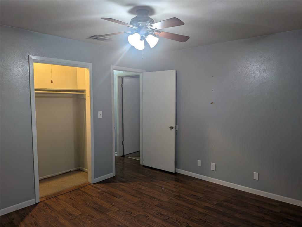 2009 County Road 4619 Athens, TX 75752 - Photo 21 of 36 Unfurnished bedroom featuring dark wood-type flooring, a ceiling fan, and a closet