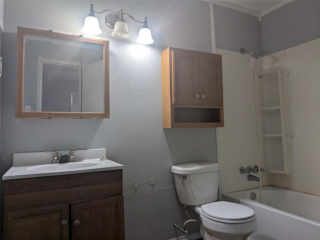 2009 County Road 4619 Athens, TX 75752 - Photo 25 of 36 Bathroom featuring vanity, shower / bath combination, and a textured wall